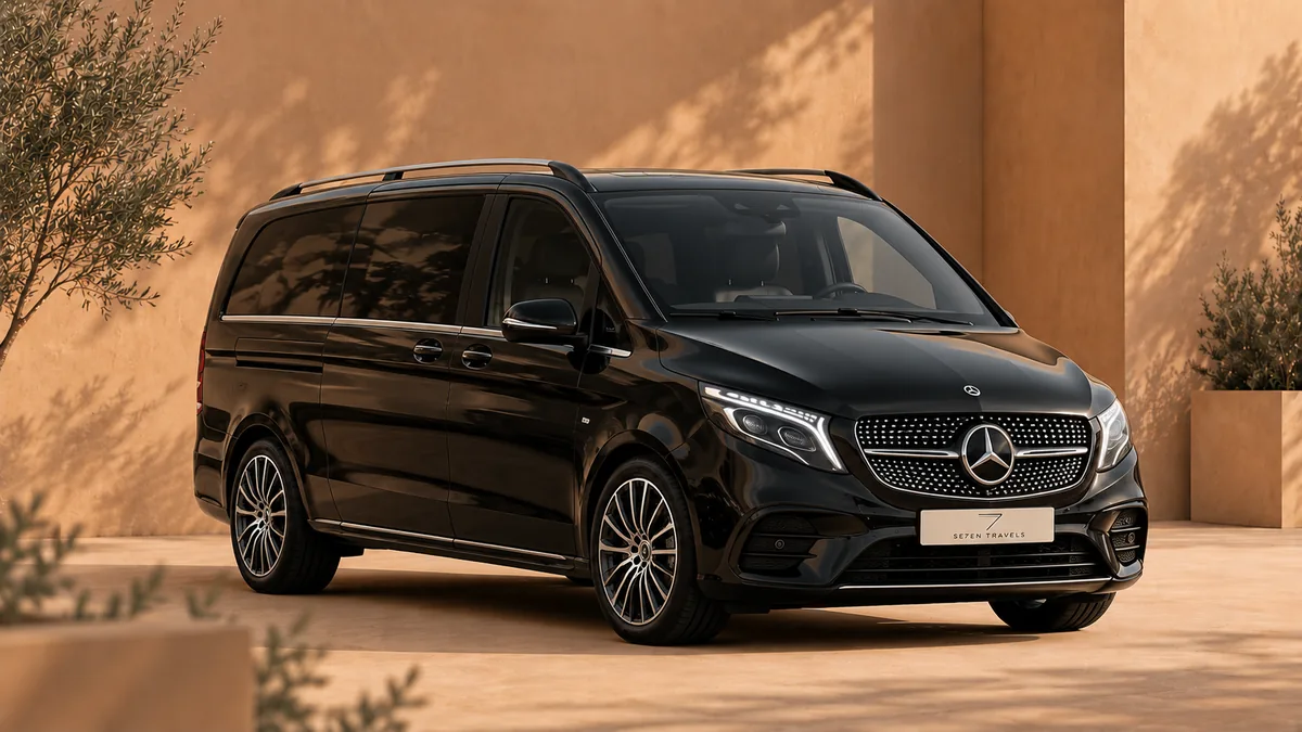 Schwarze Mercedes V-Klasse, geparkt in einem sonnigen Innenhof vor einer warmen ockerfarbenen Wand