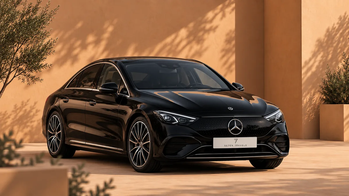 Schwarzer Mercedes EQE, geparkt in einem sonnigen Innenhof vor einer warmen ockerfarbenen Wand