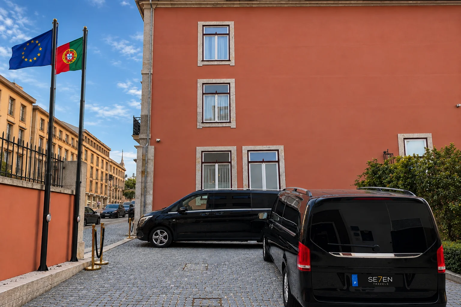 Zwei schwarze Mercedes-Vans, die auf einem Kopfsteinpflaster aus Granit vor einem terrakottafarbenen Gebäude stehen